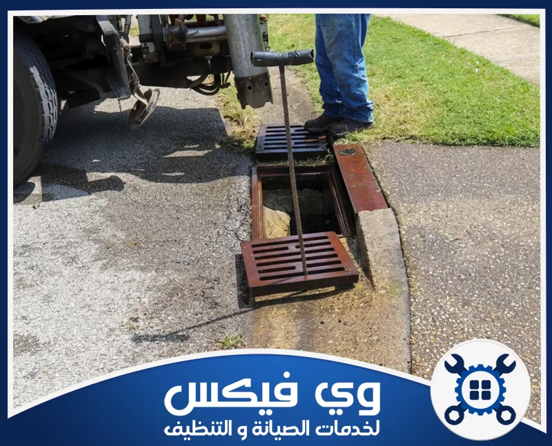 سحب مجاري بحفر الباطن 0544909308 حفر الباطن عامل يفتح غطاء بالوعة في الشارع لبدء عملية سحب مجاري بحفر الباطن وتنظيفها.