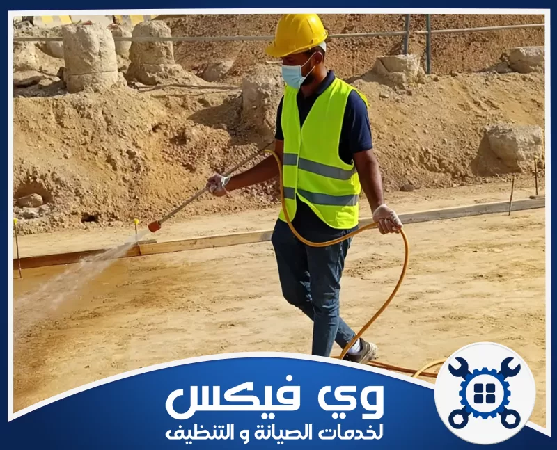 شركة رش مبيد بحفر الباطن معتمدة 0544909308 شركة وي فيكس مهندس تجهيز مواقع يوزع المياه على التربة داخل مشروع إنشائي مع ارتداء معدات السلامة.